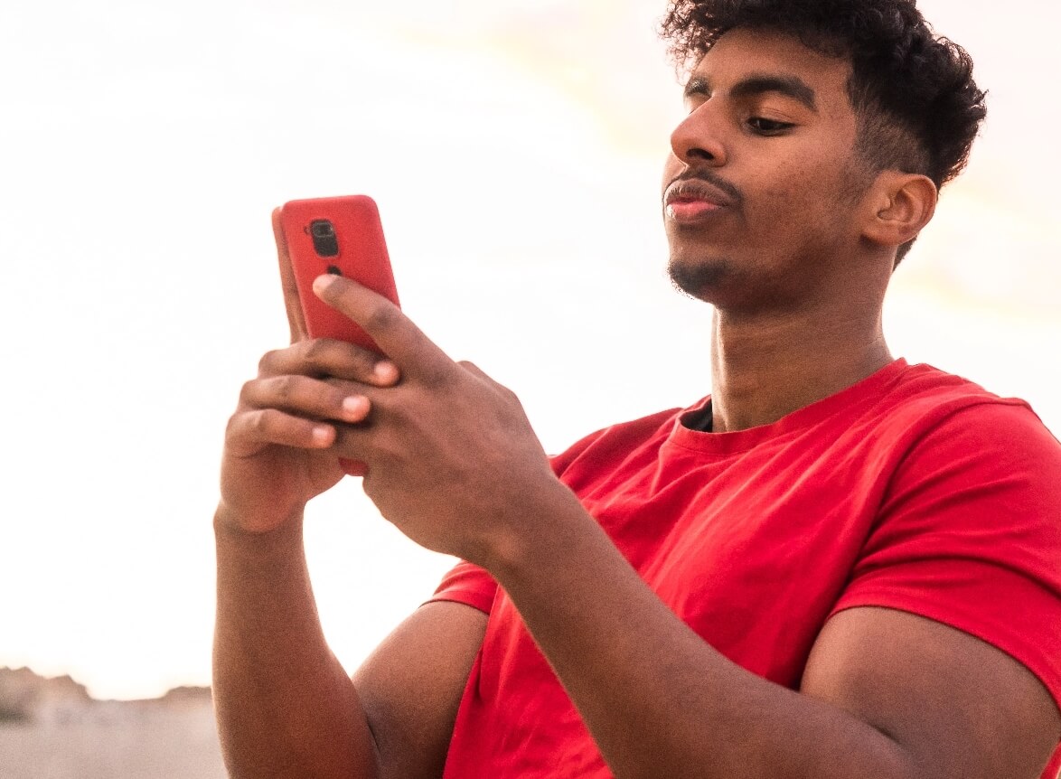 arab-young-man-with-red-t-shirt-in-a-sunset-typing-2023-11-27-05-30-38-utc@2x
